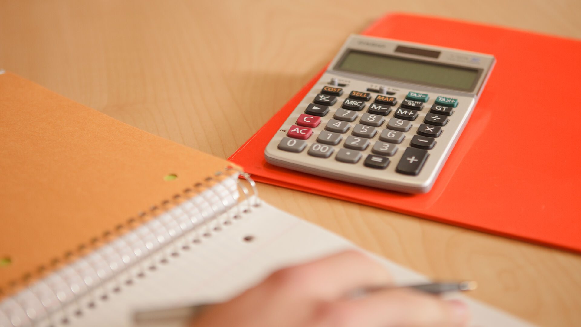 calculator on desk with notebook