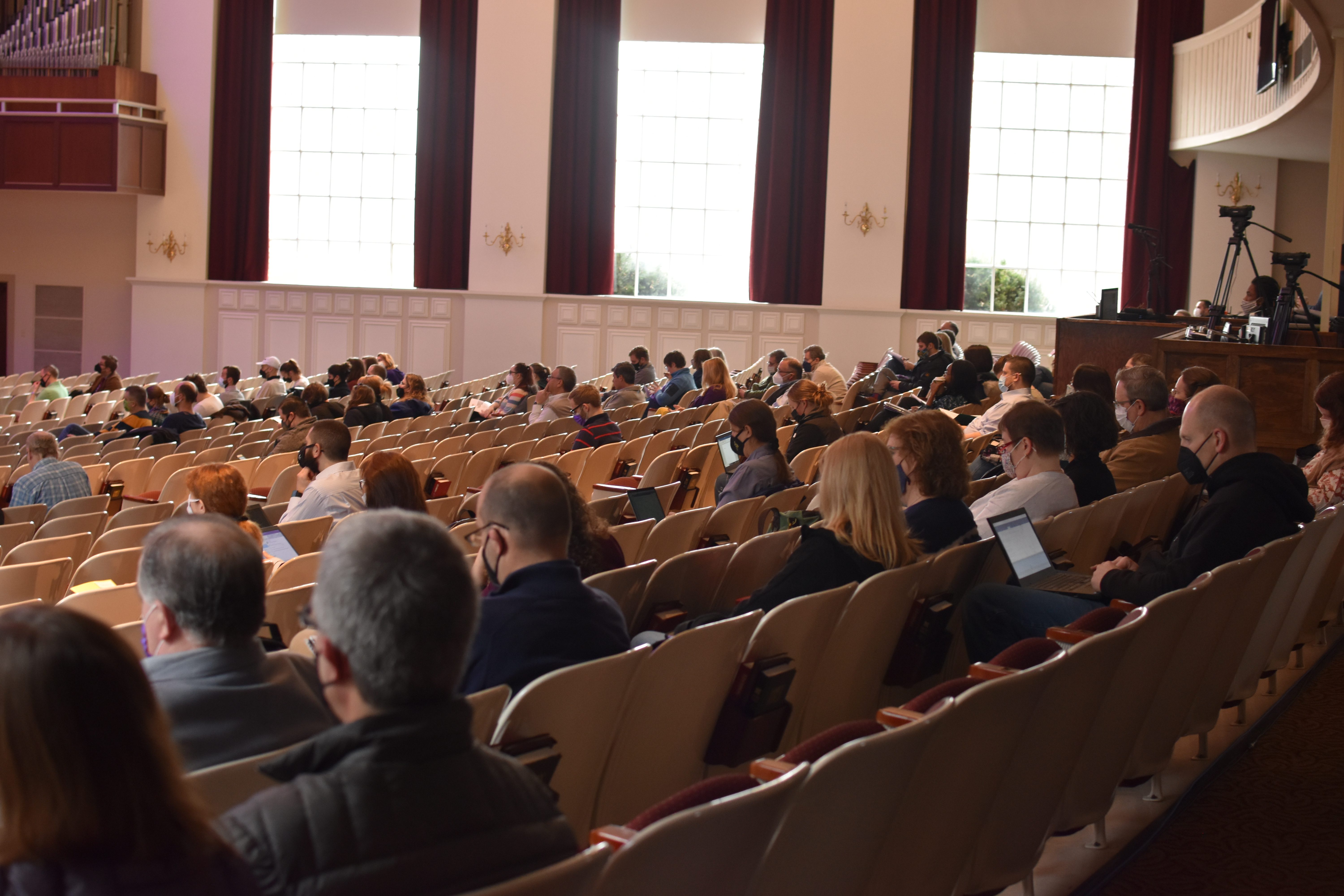 Staff and faculty sitting in auditorium.
