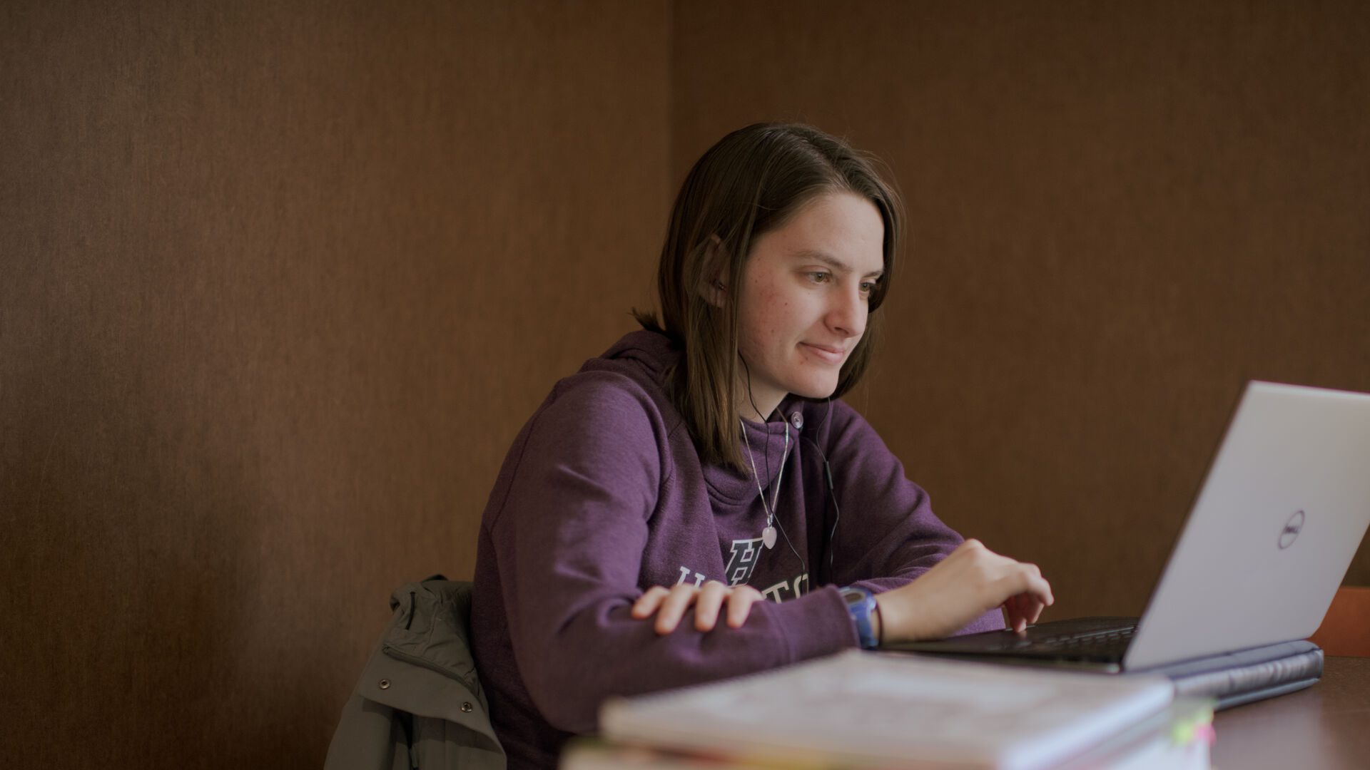 Houghton Universitystudent sitting at laptop.