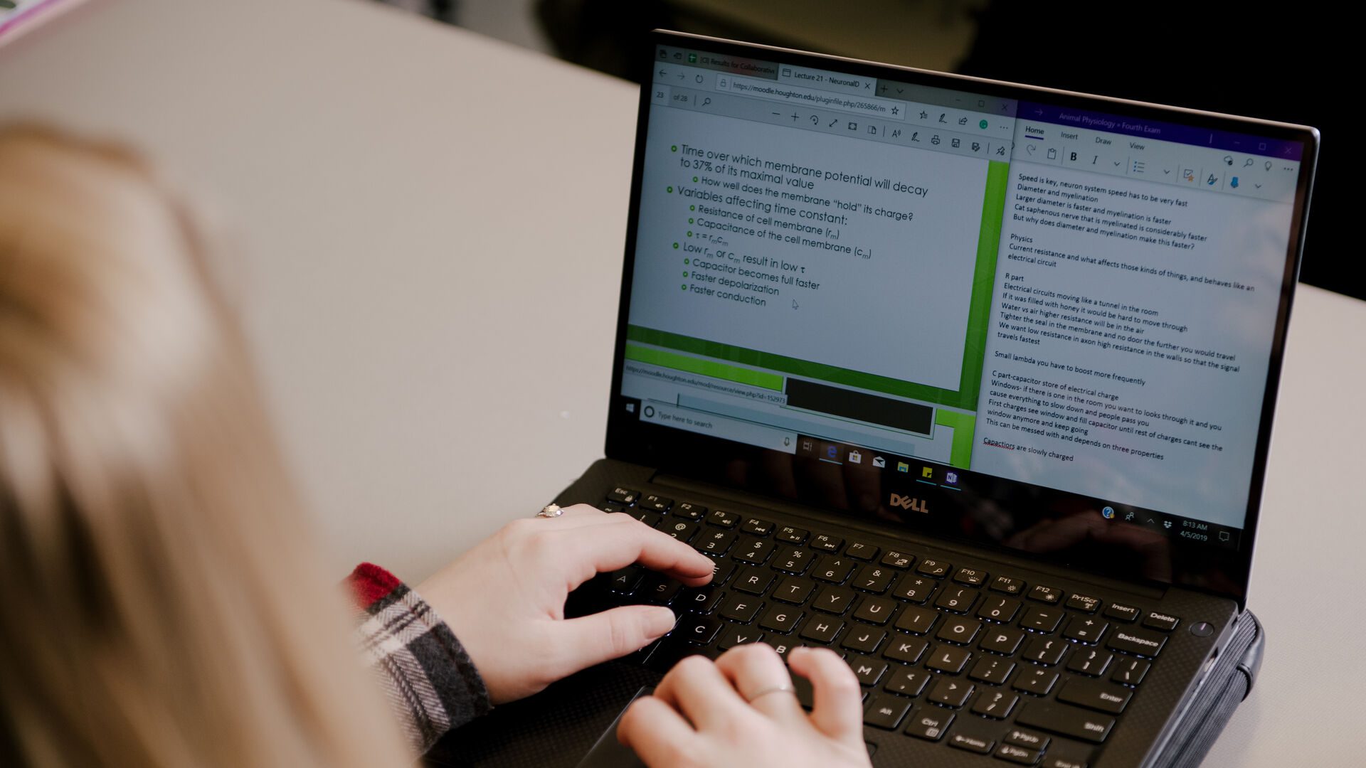 Student typing on laptop.