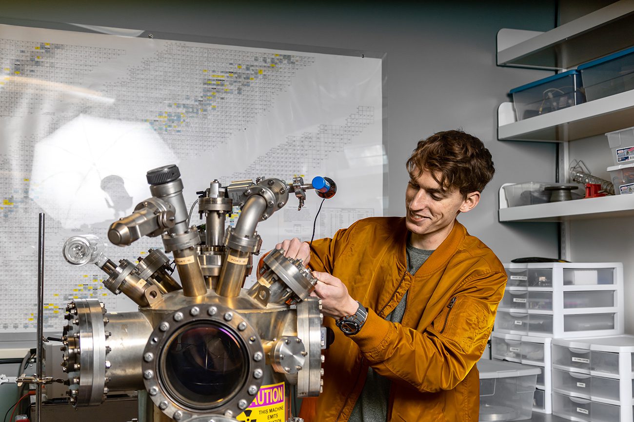 Houghton Universitystudent working with electrostatic confinement fusion instrument in physics lab.