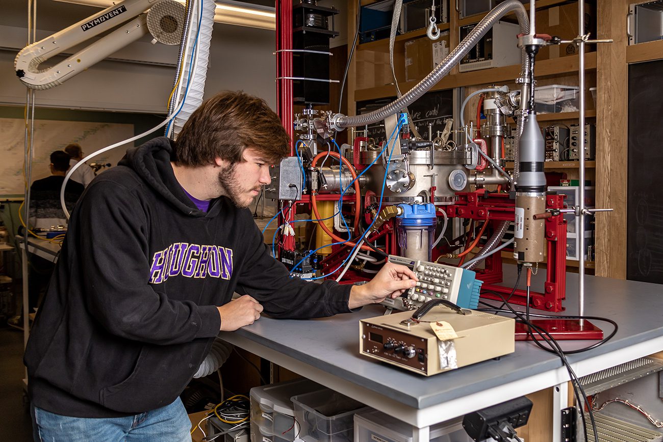 Houghton Universityphysics student working with instruments in physics lab.