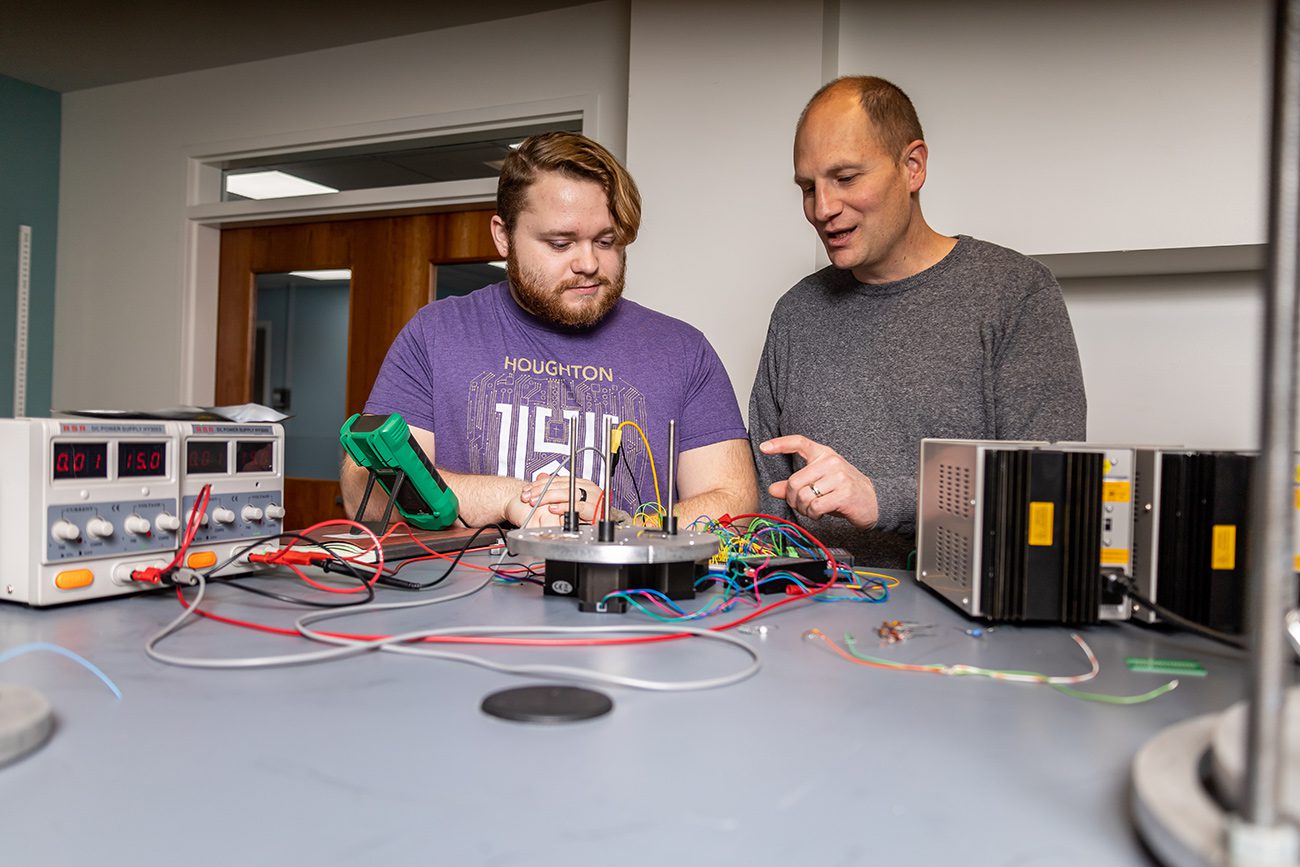 Houghton Universitystudent working with professor in physics lab.
