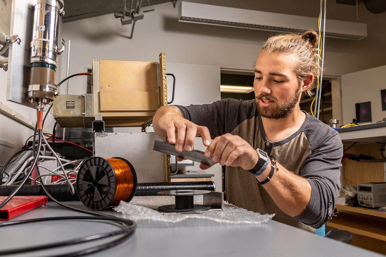 Houghton Universitystudent working with equipment in physics lab.