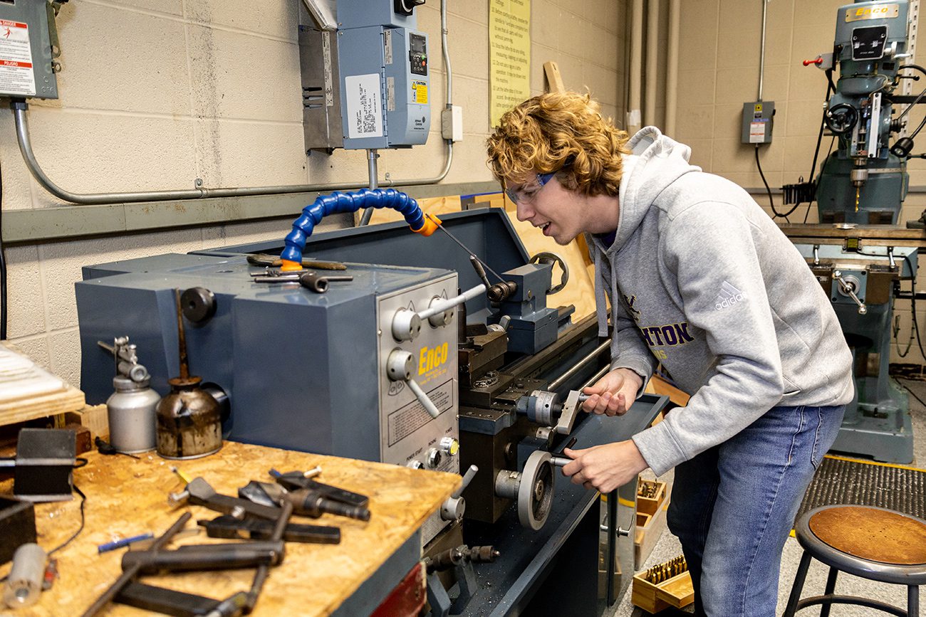 Houghton Universityphysics student working in machine lab.