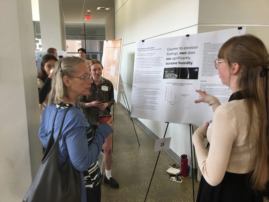 Female ����ר�� students presenting her poster to others