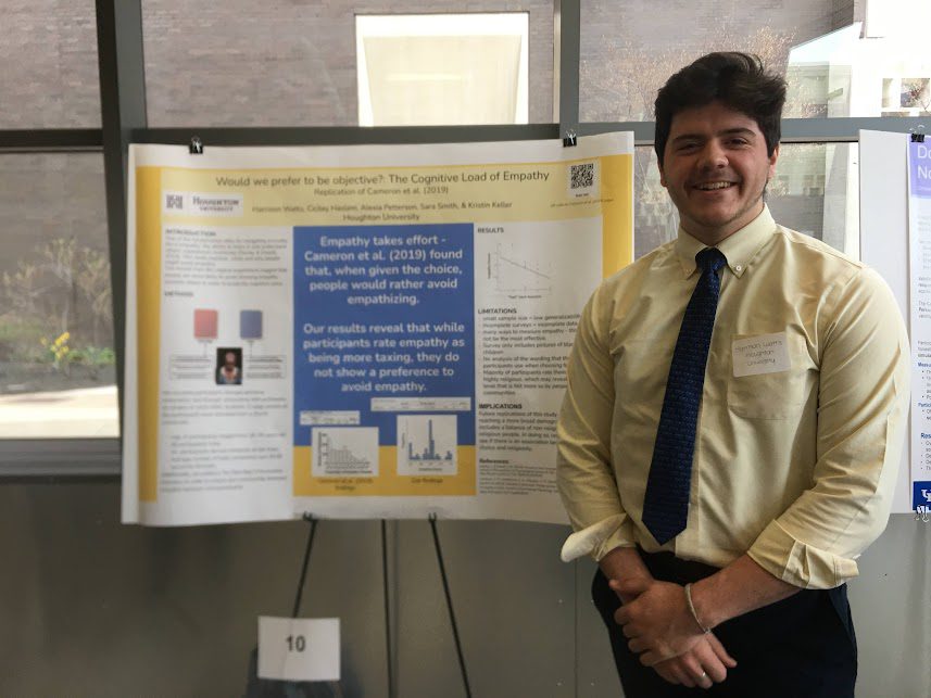 Houghton Universitystudent presenting his research poster at psychology conference.