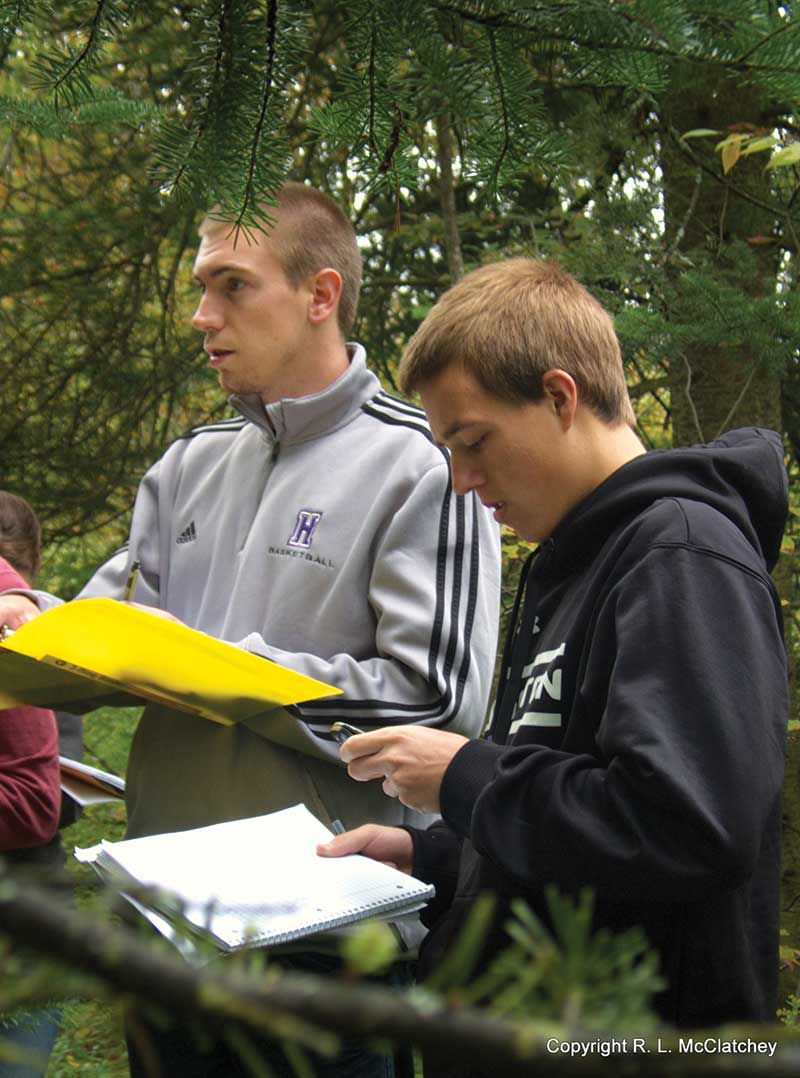 Houghton Universityalumnus Jordan Scott taking notes.