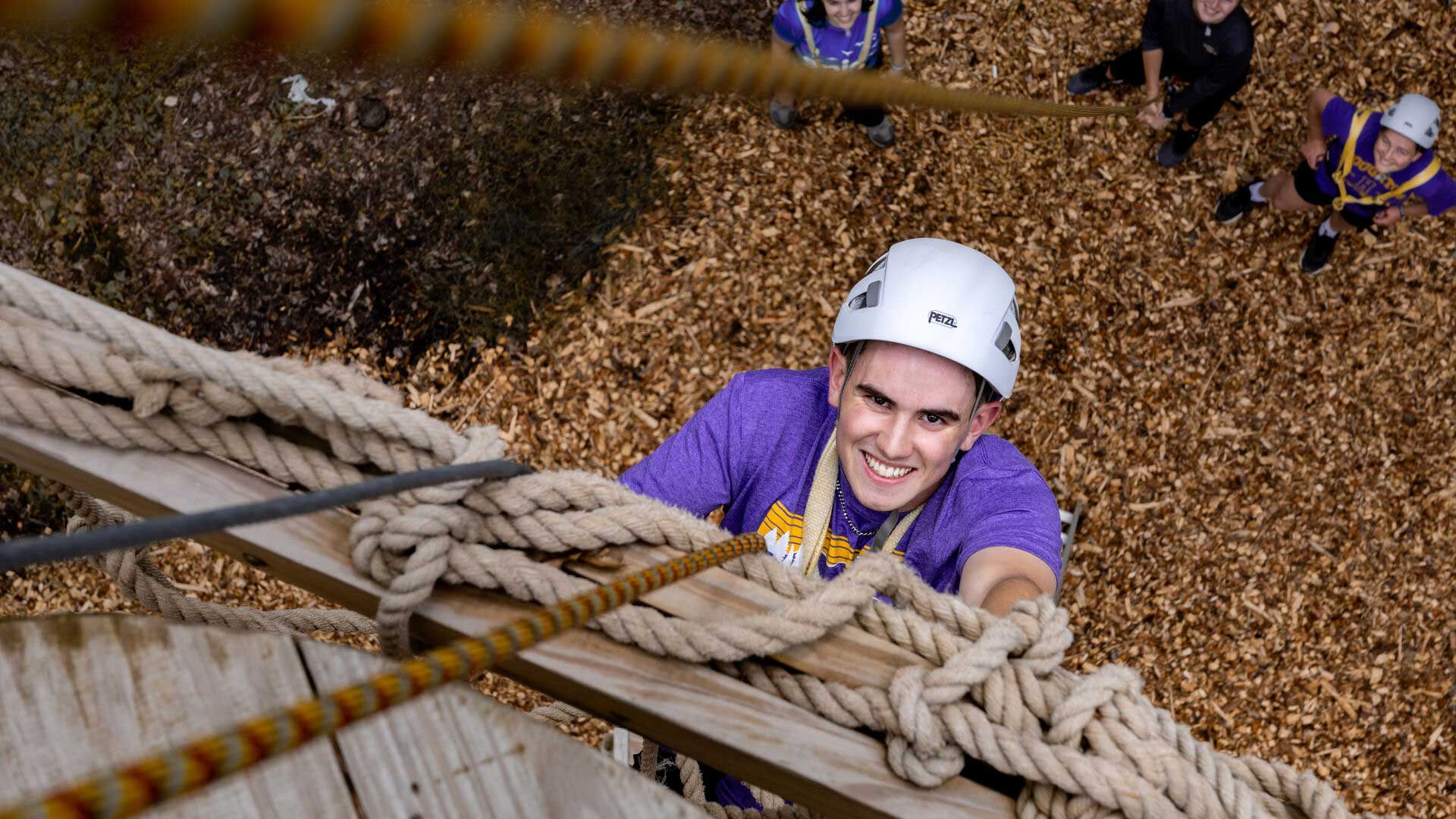 Houghton Universitystudent climbing rope net at EPIC Adventures Ropes Course.