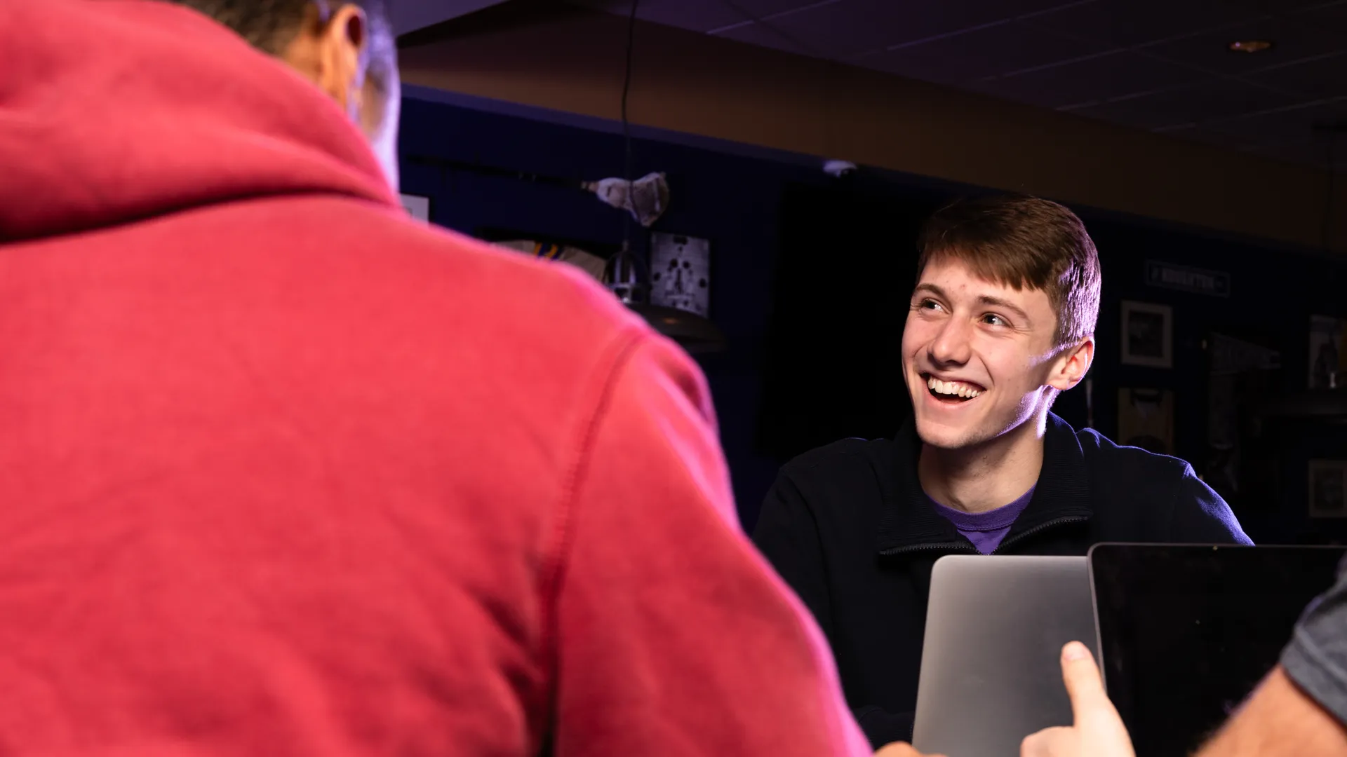 Houghton Universitystudent sitting with laptop hanging out with friends.