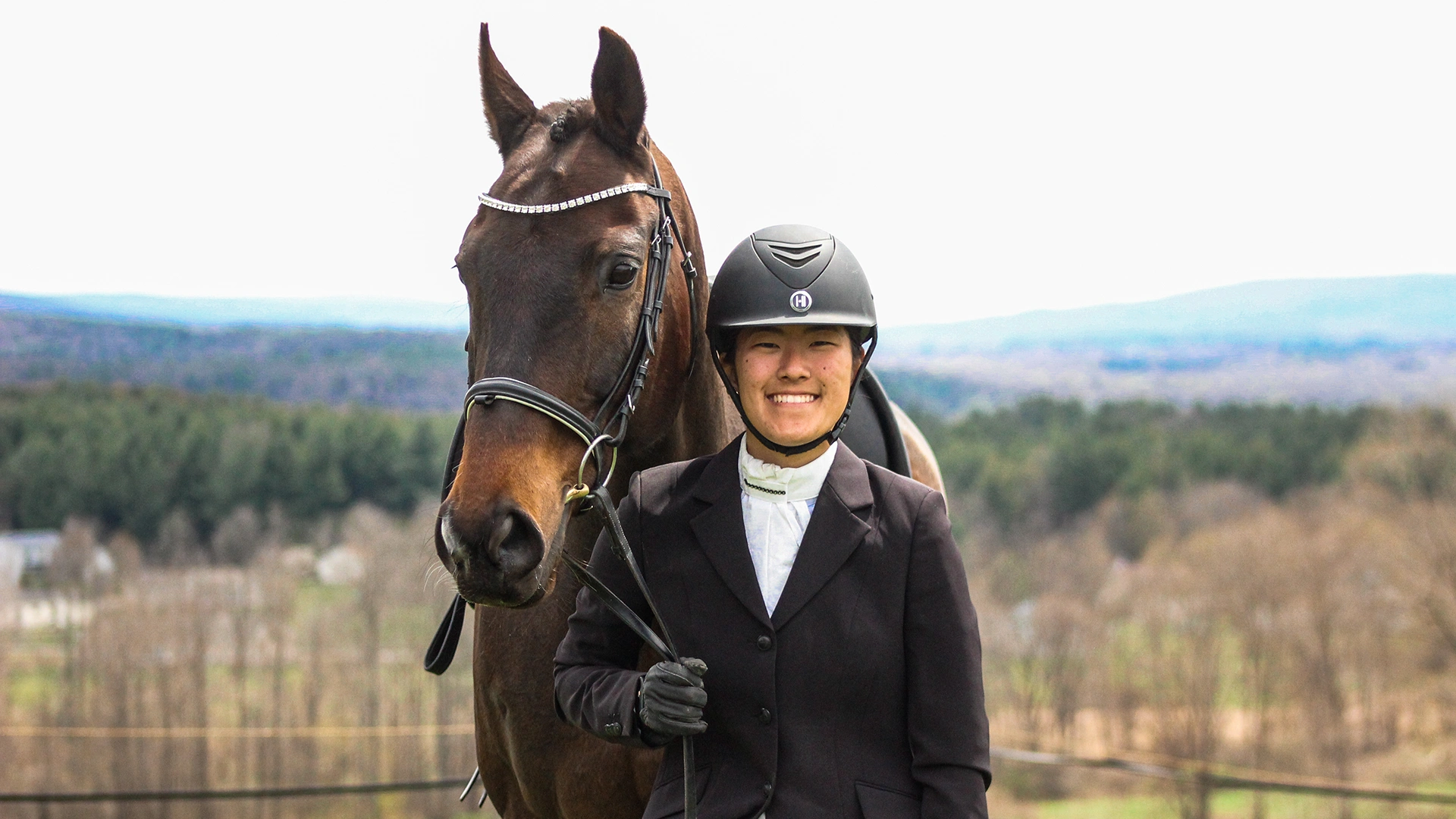 Houghton Universityequestrian student standing with horse outside