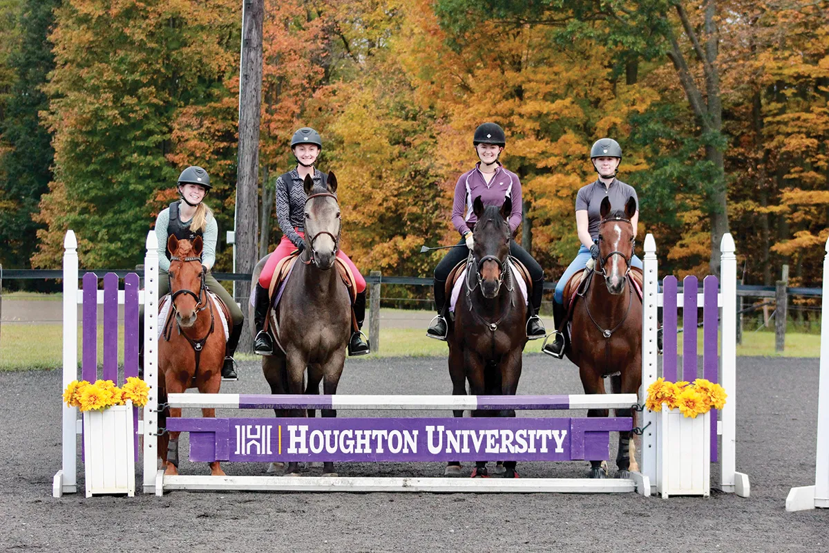 Four ����ר�� equestrian majors sitting on their horses by jump at Equestrian Center.