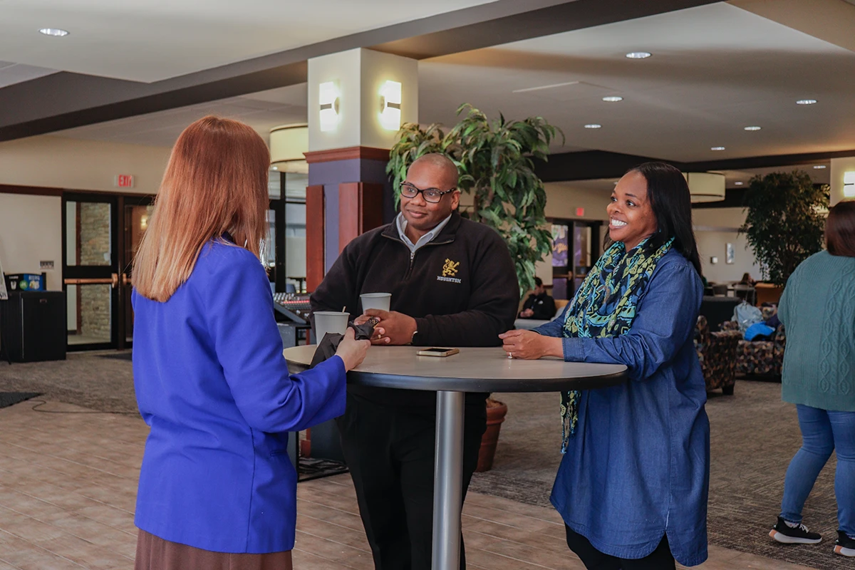 Houghton Universitypresident Wayne Lewis with wife Monica Lewis speaking with staff member.