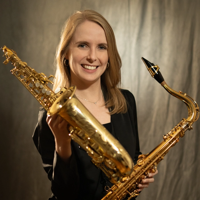 Houghton Universitymusic faculty member Anne Kunkle holding saxophones.
