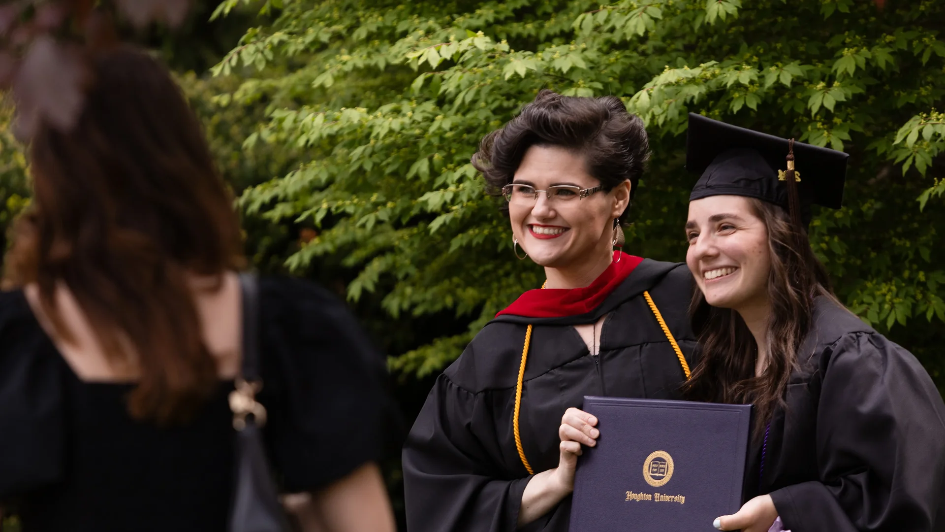 Houghton Universitygraduate standing with professor for photo.