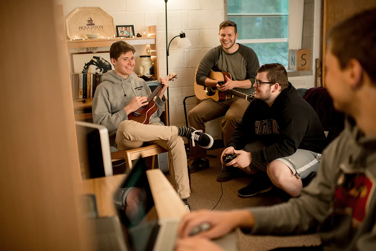Houghton Universitystudents hanging out together playing music in a Shenawana Hall.