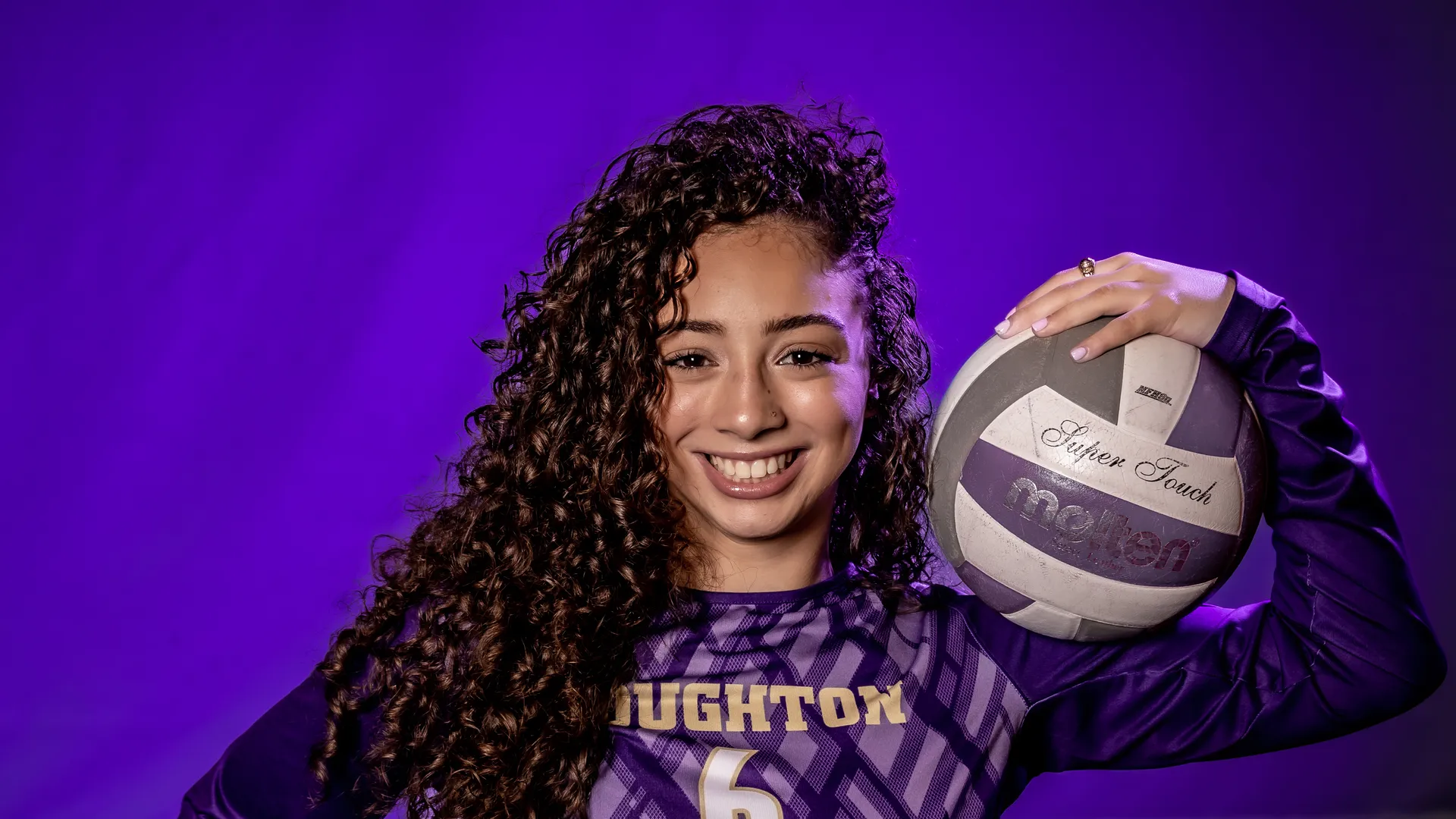 Houghton Universityathlete and sport, recreation and wellness management major Natalie Rivera in uniform holding volleyball.
