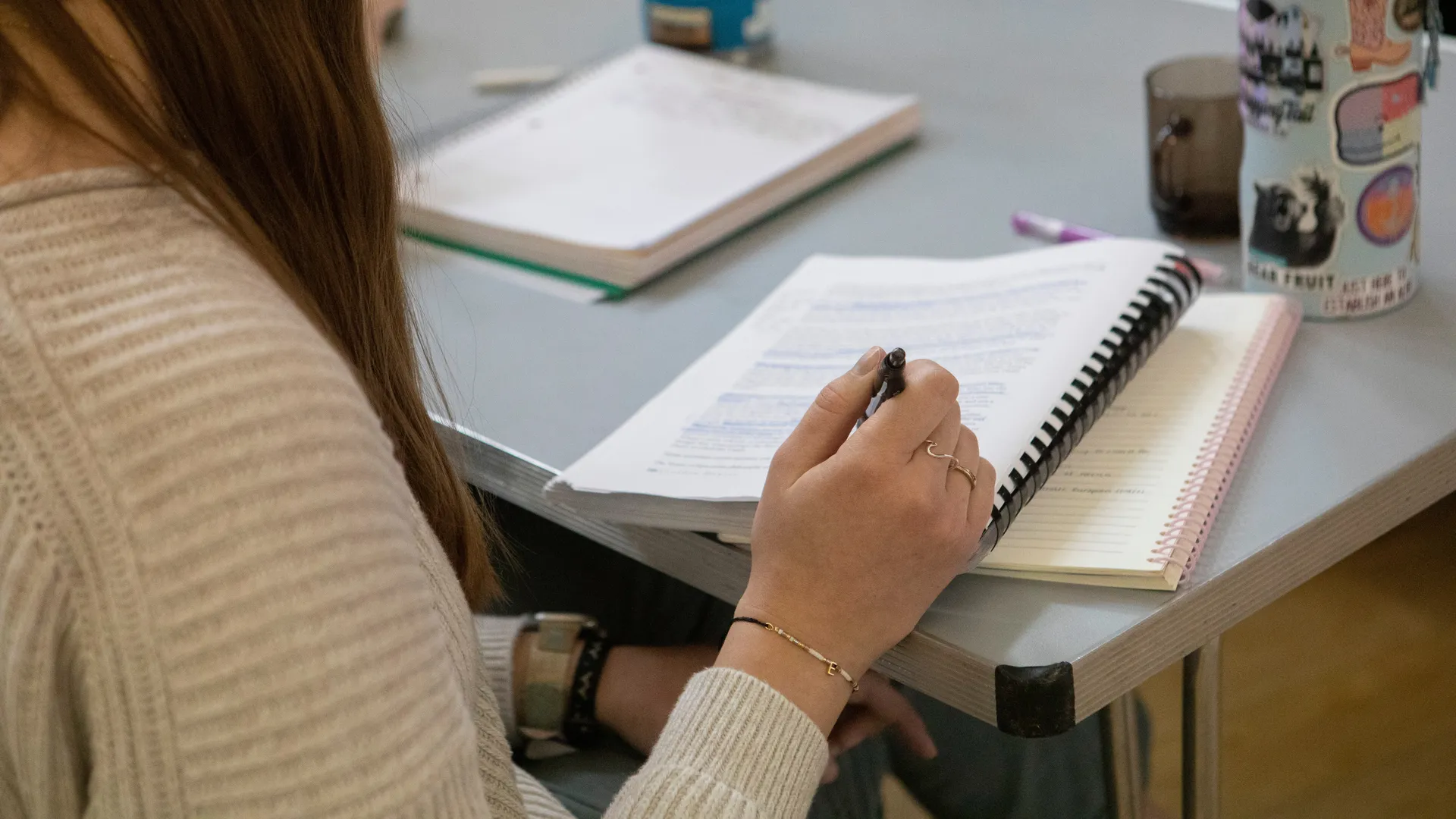 Houghton Universitystudent writing in and highlighting text.