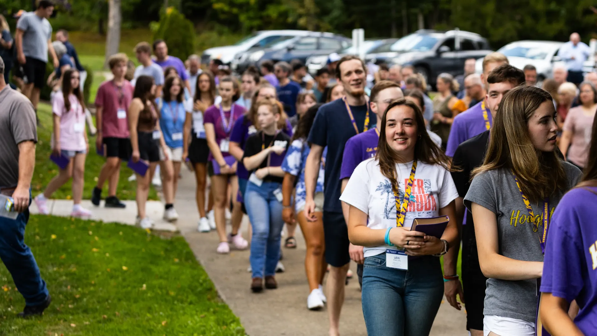 First year ����ר�� students walking out of chapel with their new purple bibles.