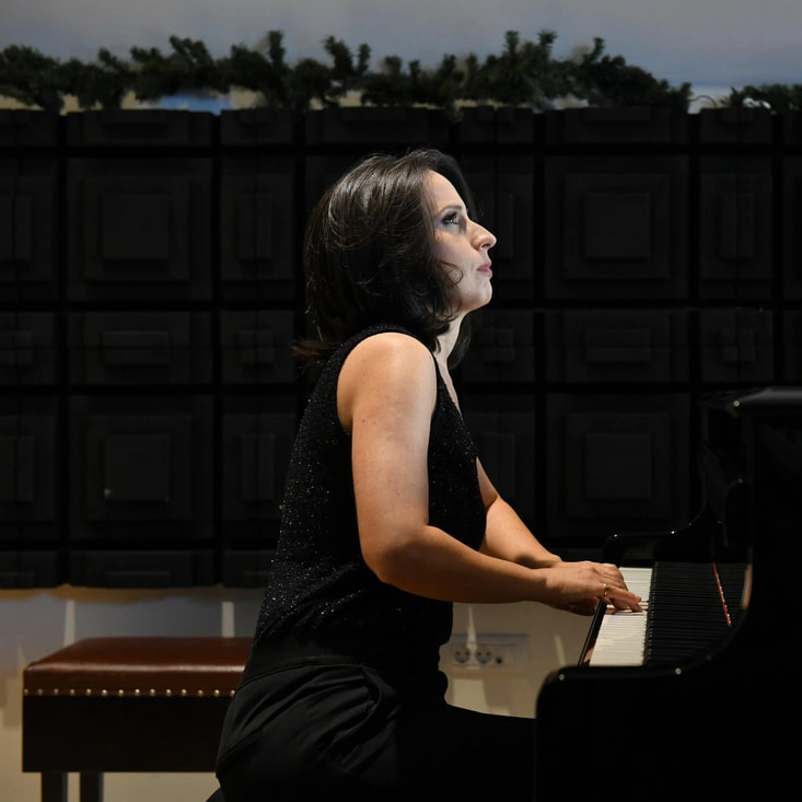 Pianist Kalina Mrmevska playing at a grand piano.