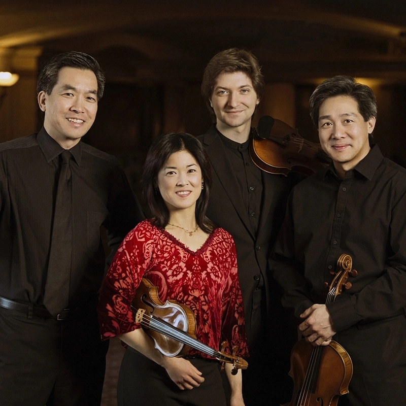 The four members of the Ying Quartet standing together with their string instruments.