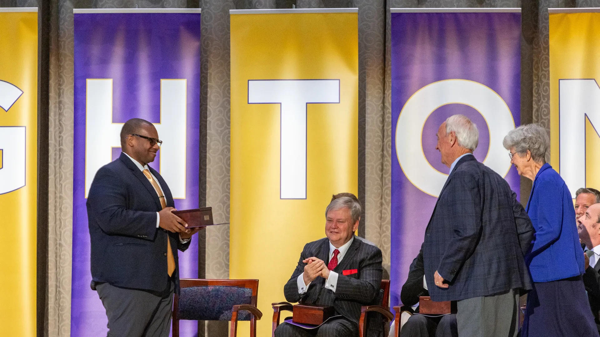 Houghton Universitypresident Dr. Wayne Lewis presenting an alumni award to Doug and Barbara Kindschi.