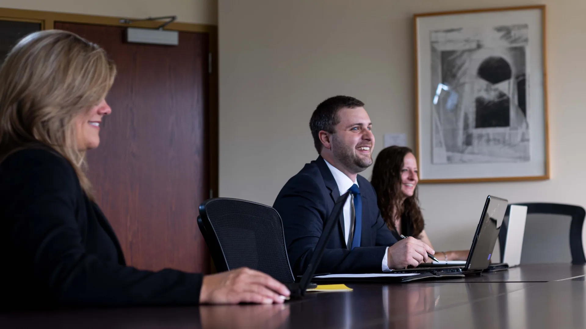 Three ����ר�� MBA students sitting at large conference table.