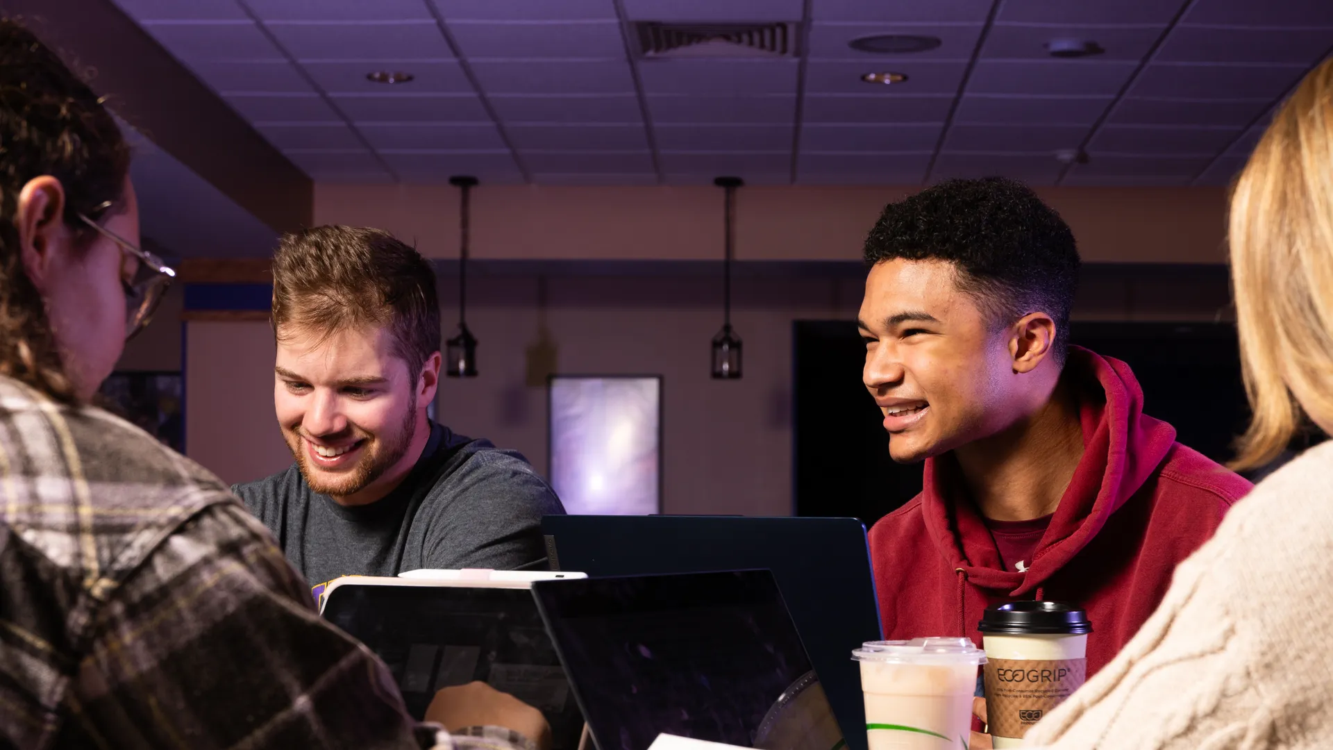 Houghton Universitystudent sitting in lounge together with laptops and coffee.