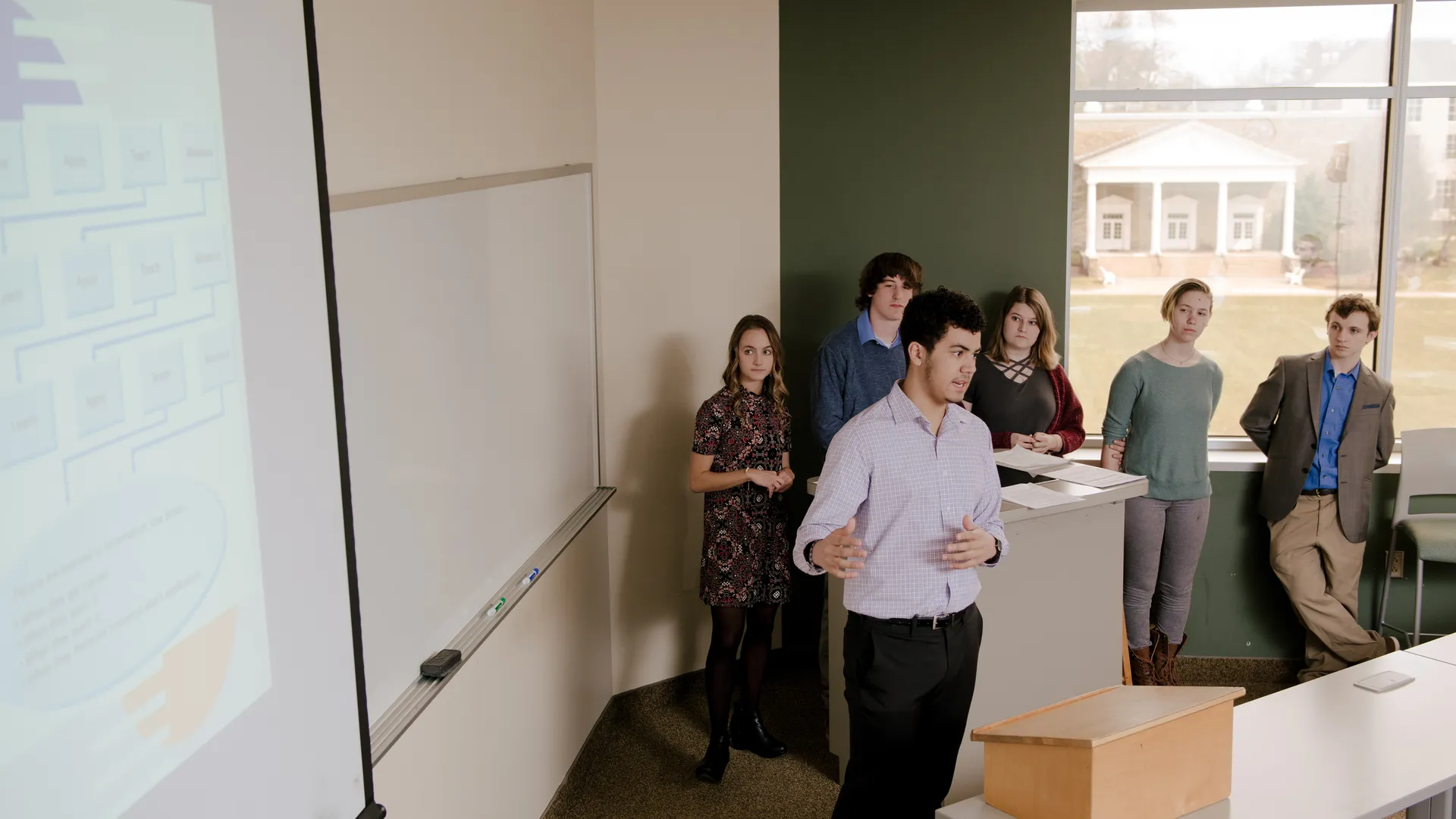 Houghton Universityorganizational management major presenting with peers in front of class.