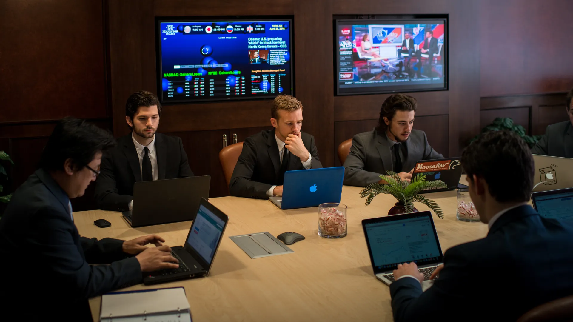 Houghton Universitybusiness students sitting around conference table in business investment center.