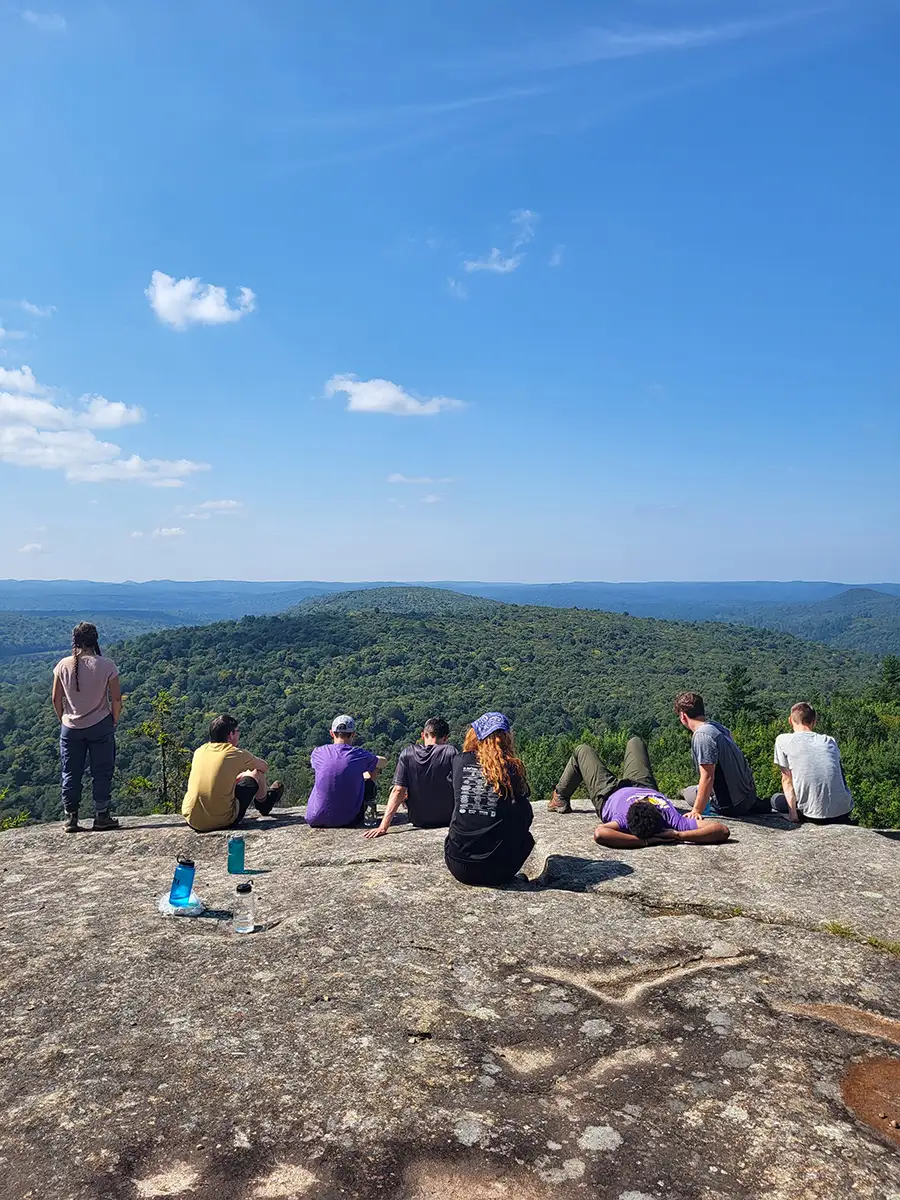 Houghton UniversityHighlander Wilderness Adventure students sitting on cliff edge on mountaintop.
