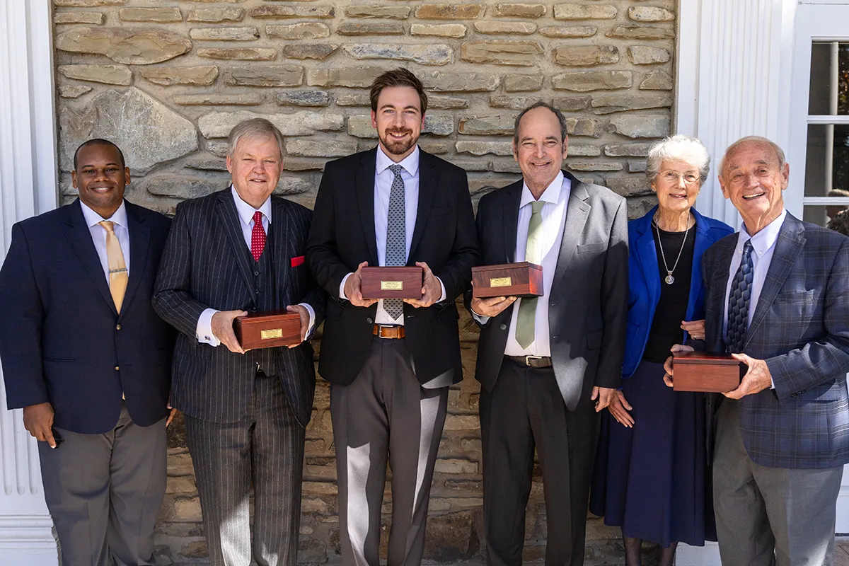 Houghton Universitypresident Wayne Lewis standing with alumni award recipients.