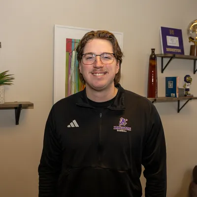 Nick pettit standing by a photo