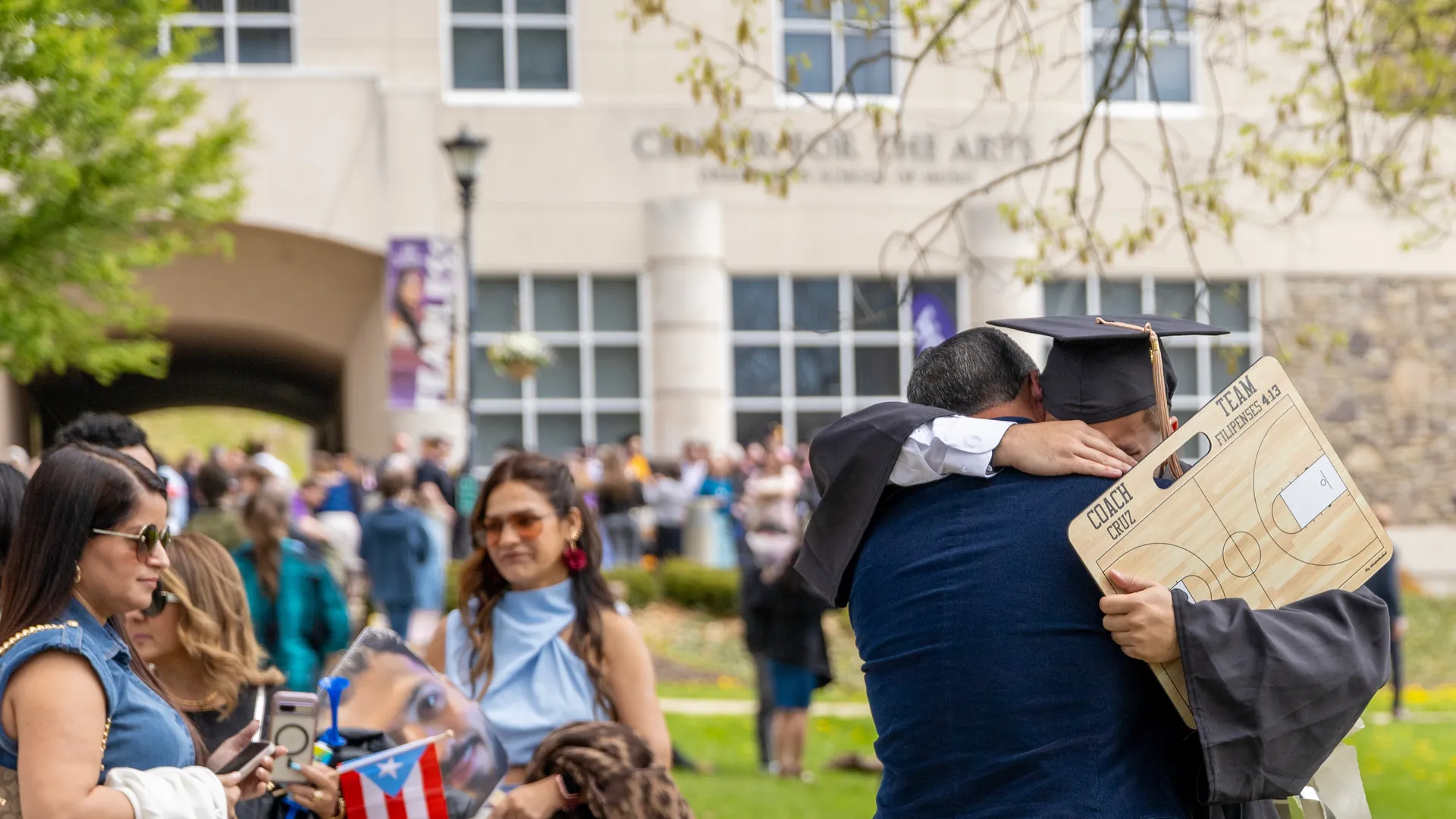 Father son hugging outside on the quad during graduation