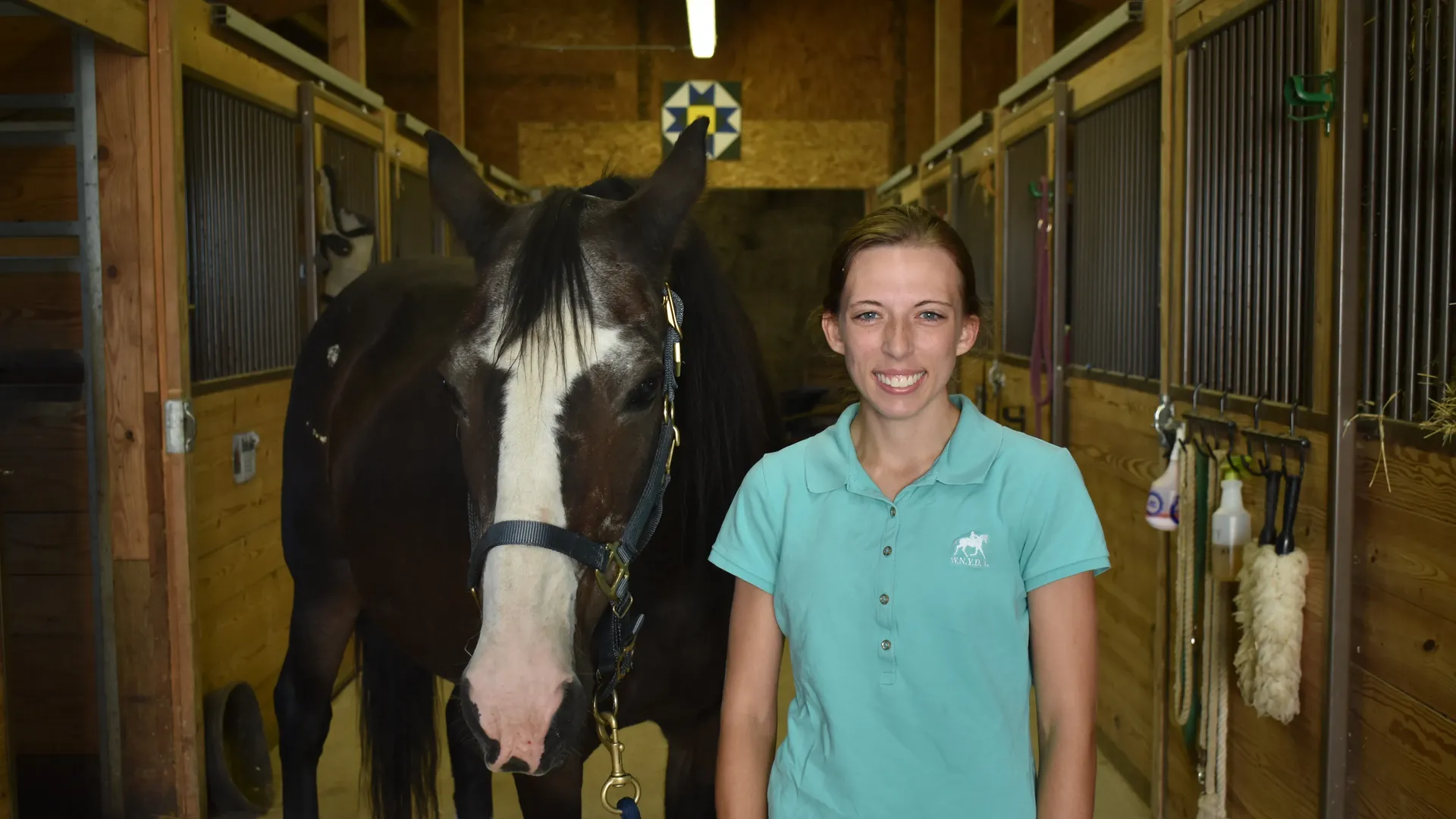 Shelby Skinner with a horse in the barn