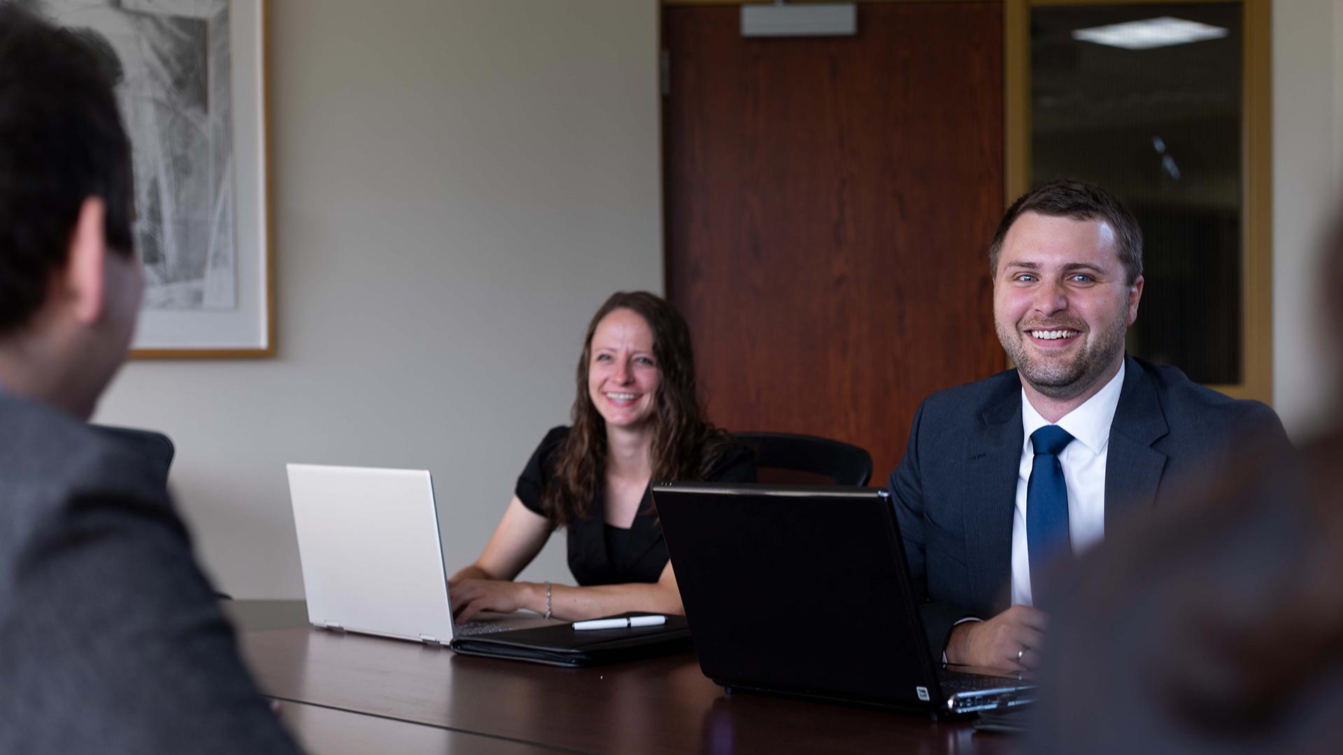 Two executives sitting at conference table who earned their online Christian MBA degree from Houghton University.