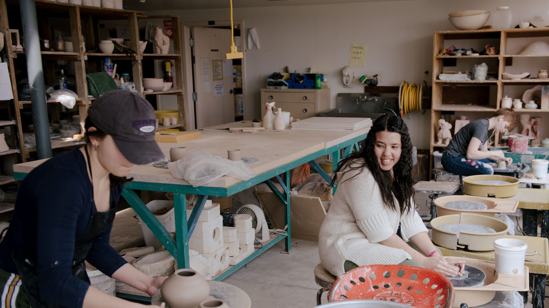 Houghton studio art major working on pottery wheel as part of their degree in ceramics.