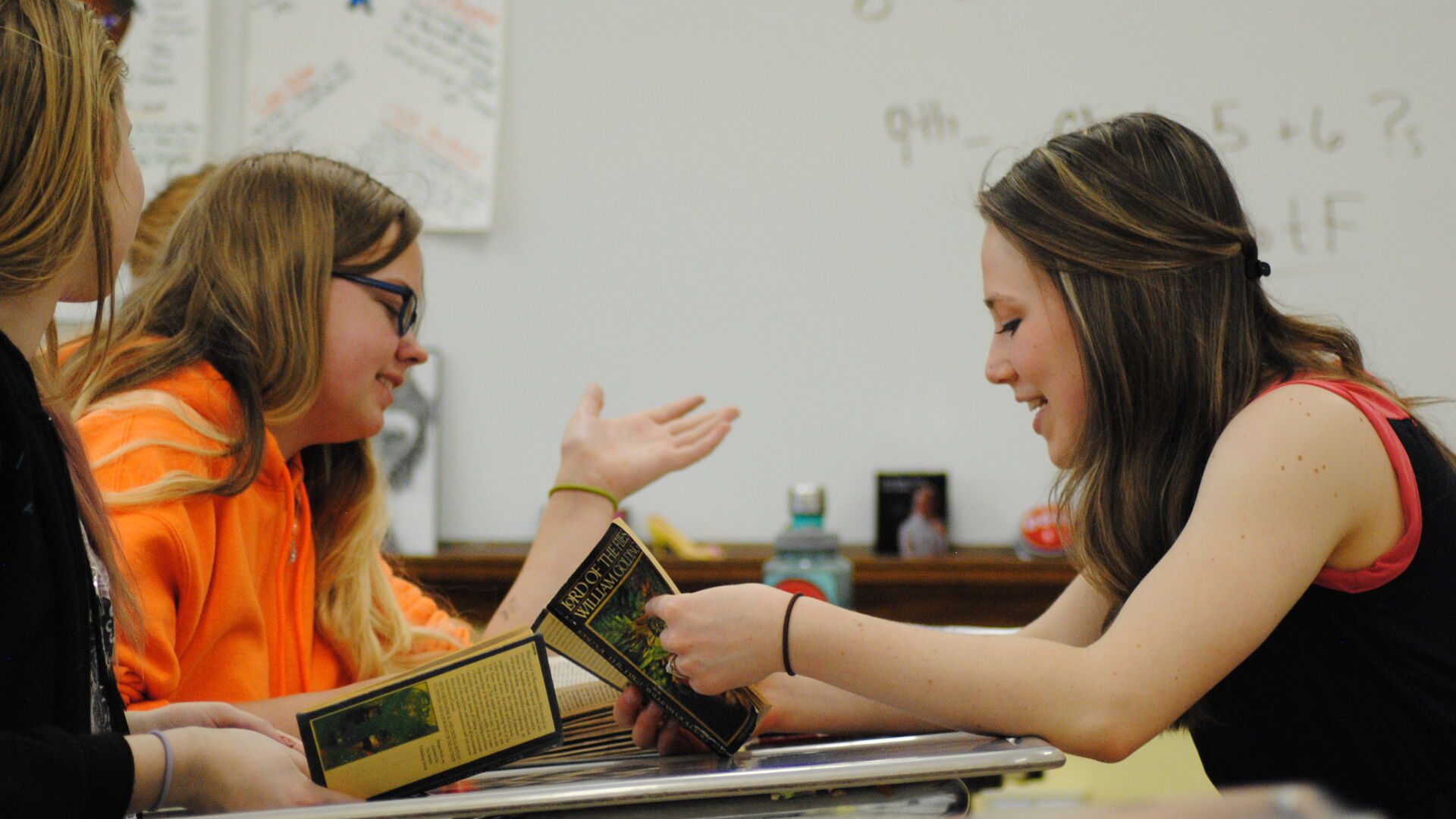 Student teacher discussing a book with a student