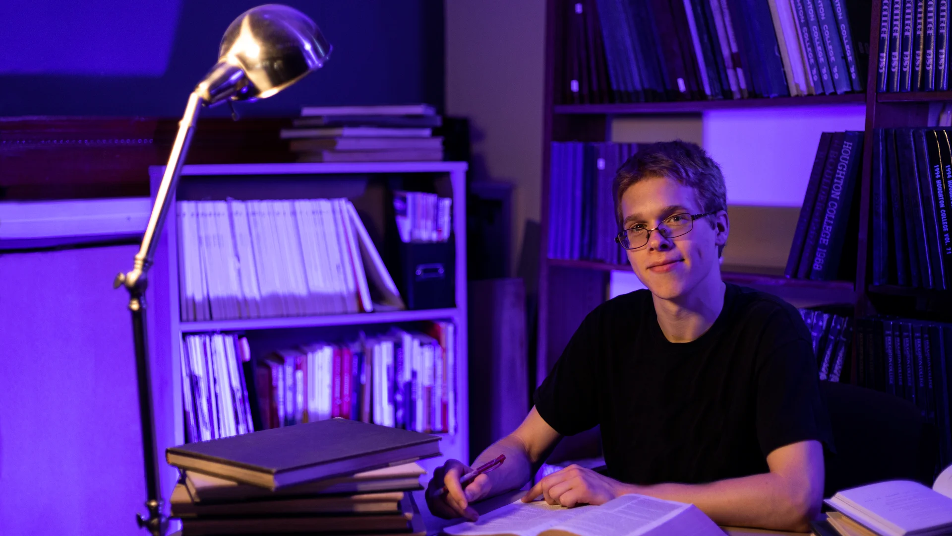 Houghton data science student Benji sitting at desk with bible.