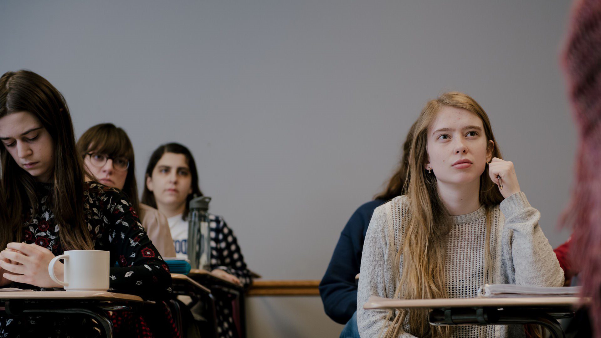 Students sitting in English class listening to lecture.