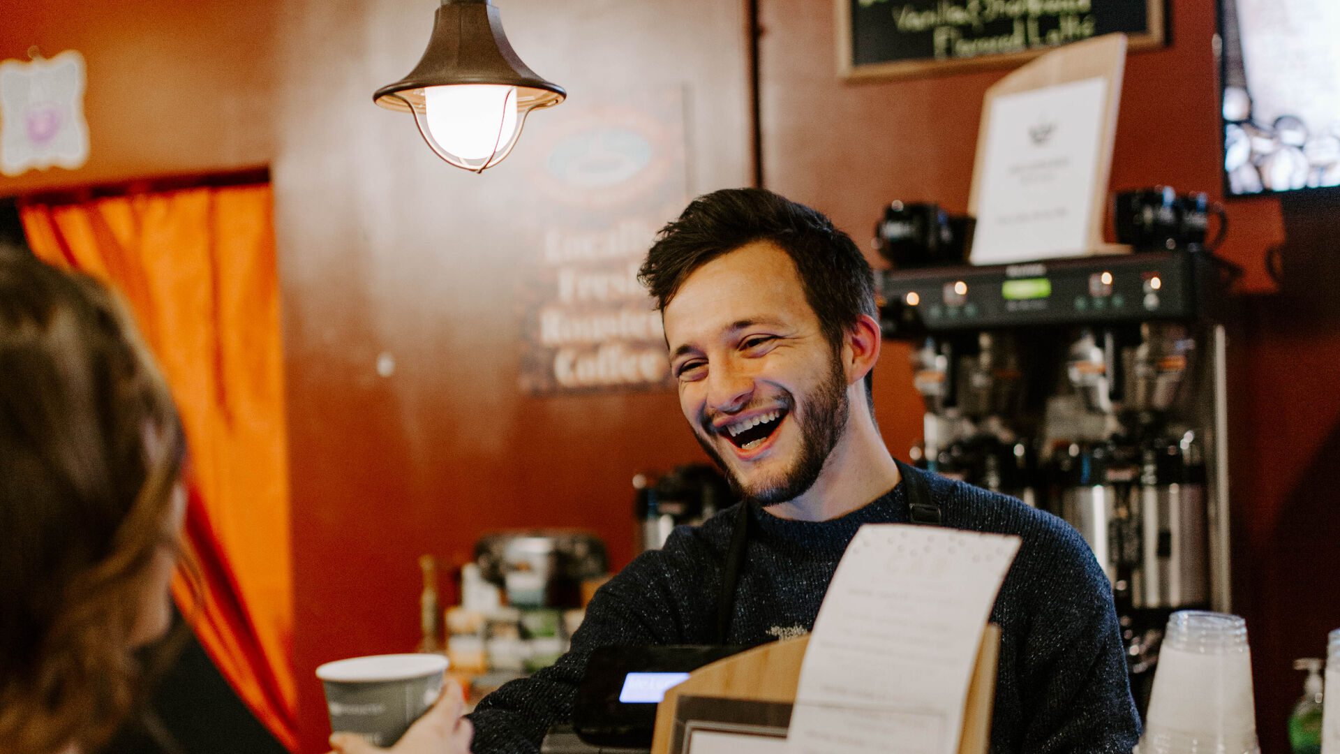 Student barista serving coffee to another student at Java 101.