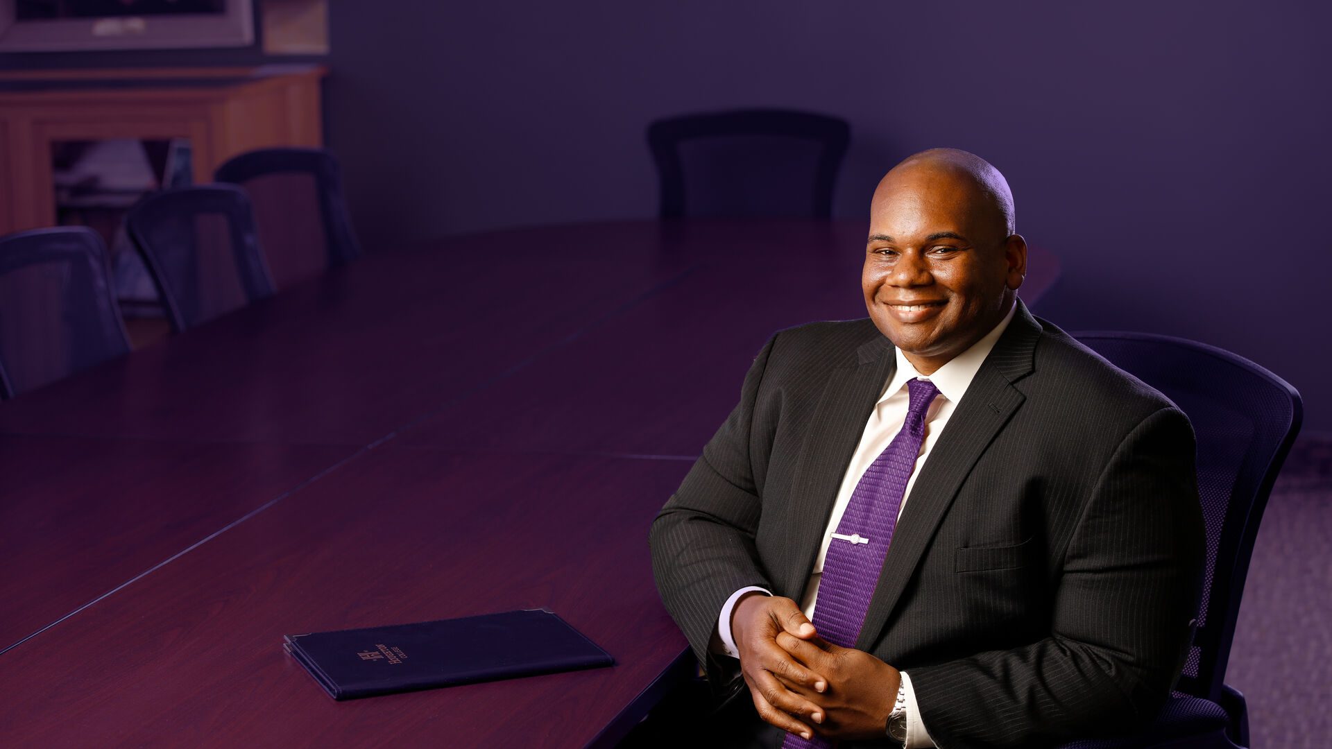Houghton President Wayne D. Lewis, Jr. sitting at conference table