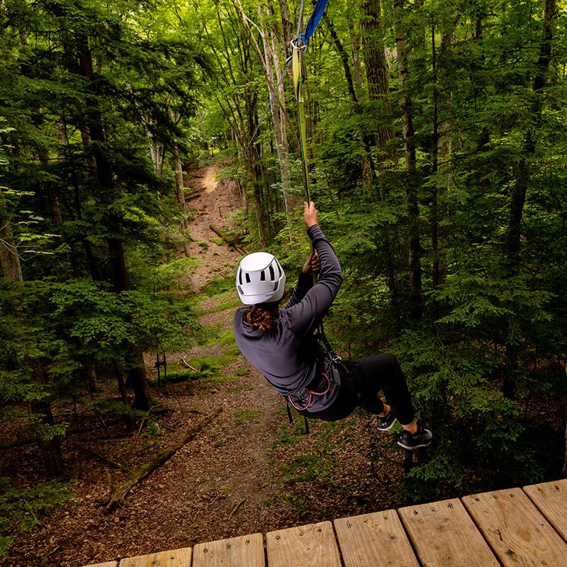 Houghton student ziplining at Epic Adventures course.