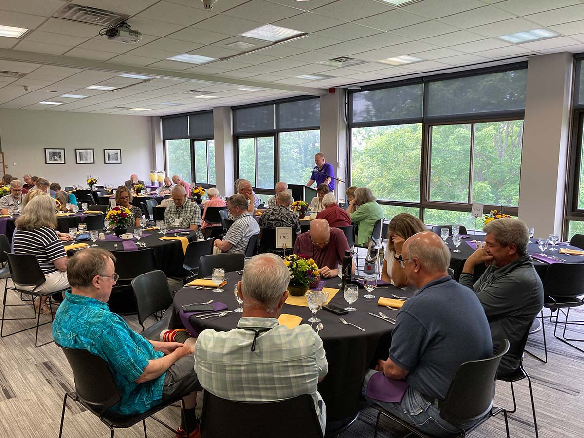 A large group of Houghton alumni sitting and listening to President Lewis speak.