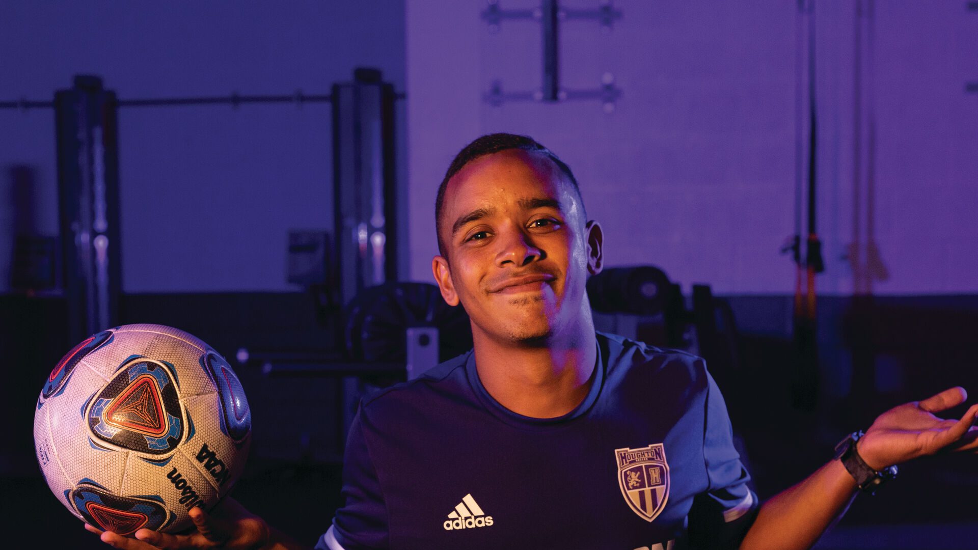 Houghton student Gabe Van Wyk wearing soccer jersey and holding soccer ball.