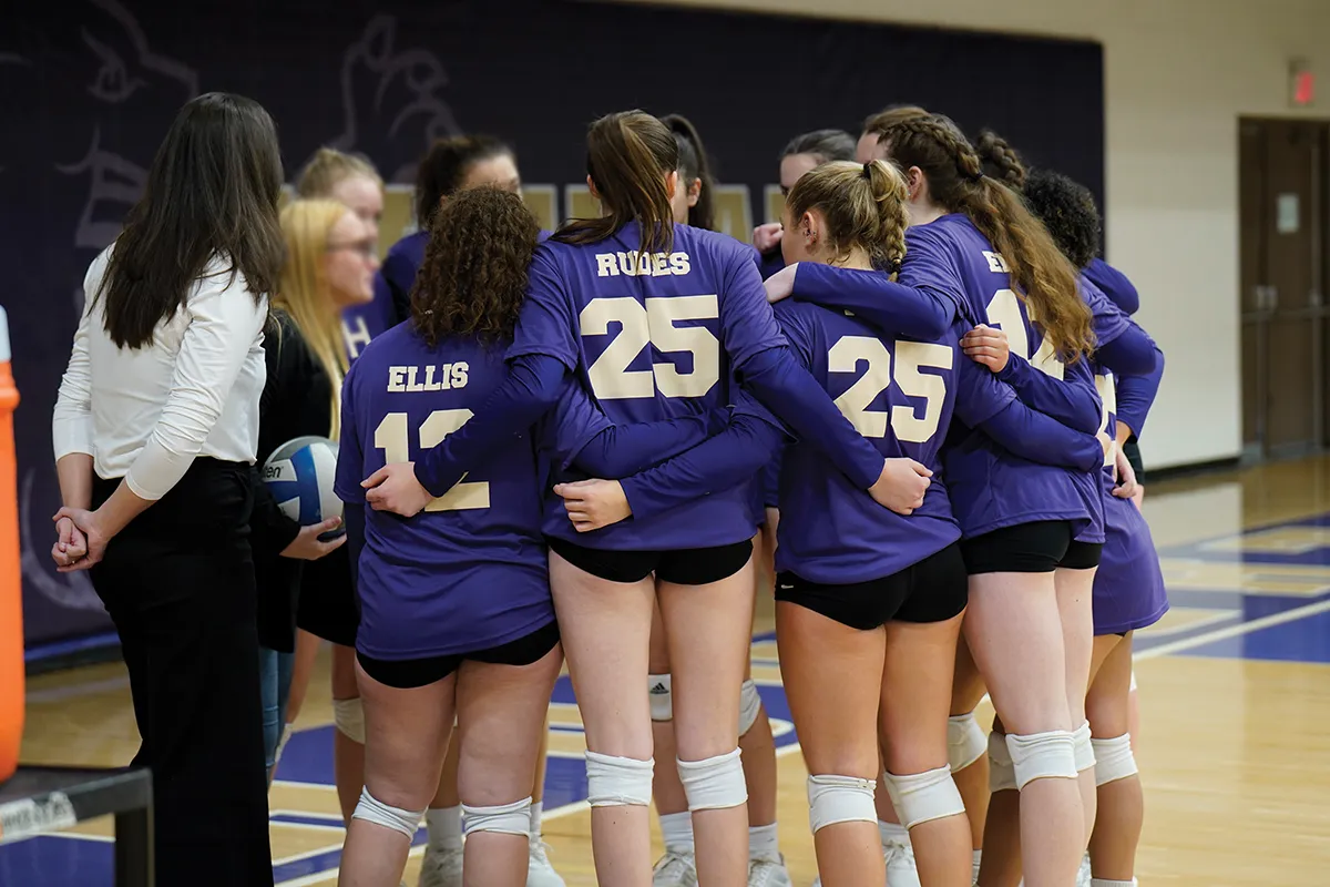 Houghton's women's volleyball team huddling together before game.
