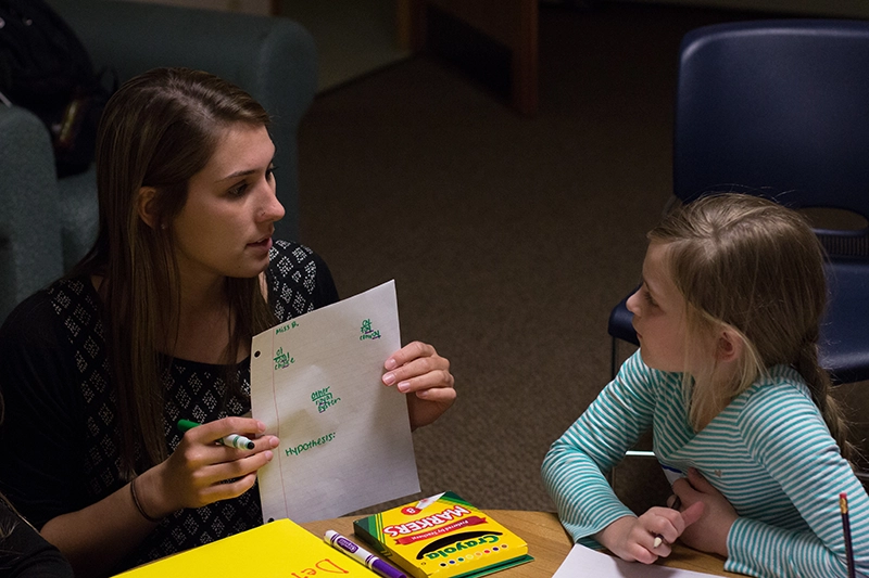 Houghton education major student working with elementary student on Literacy Day.