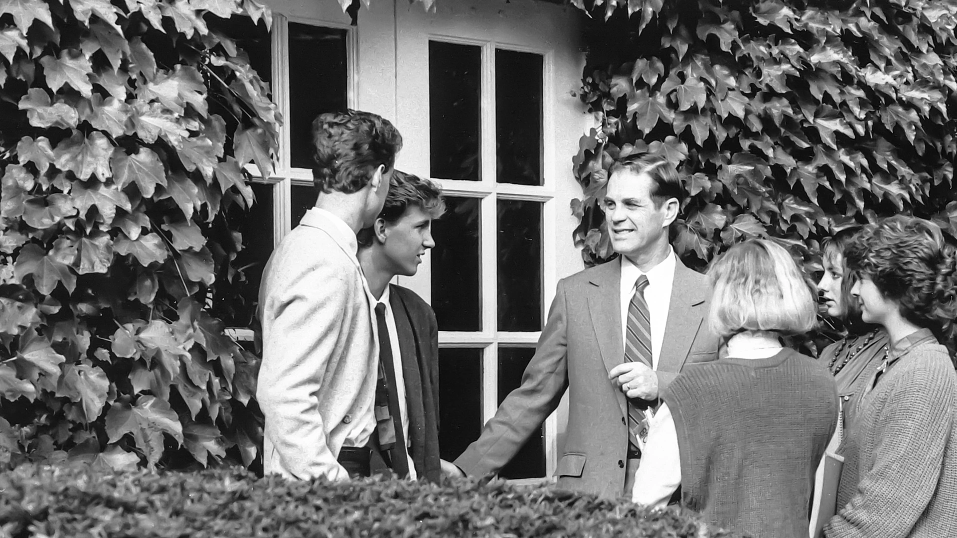 Houghton president emeritus Dan Chamberlain speaking with students outside.