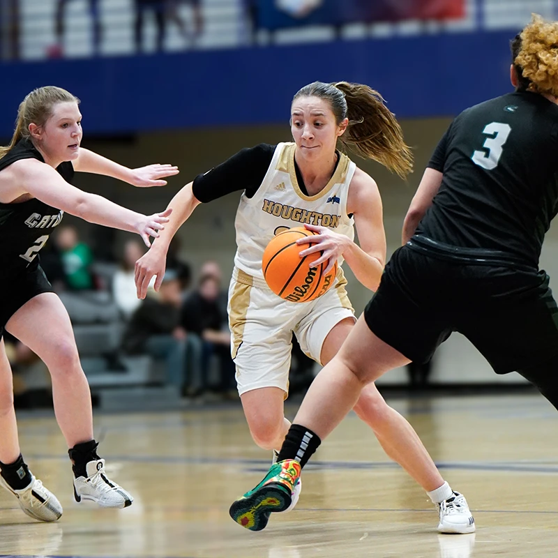 Houghton women's basketball player Kayla Camacho running play on court.