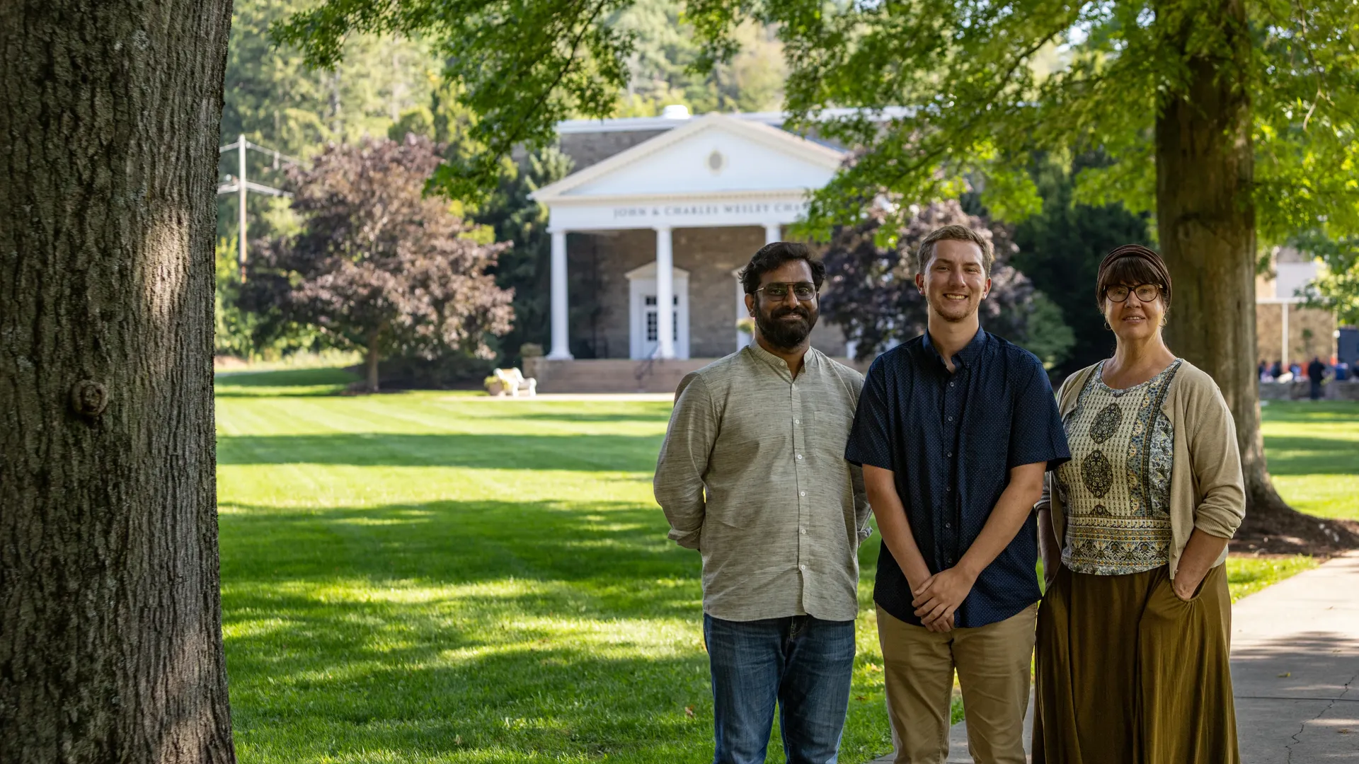 Three new ���Ͽ� faculty members standing on the quad.
